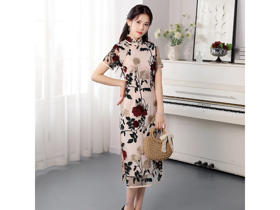 Full length view of a woman wearing a floral embroidered cheongsam midi dress.