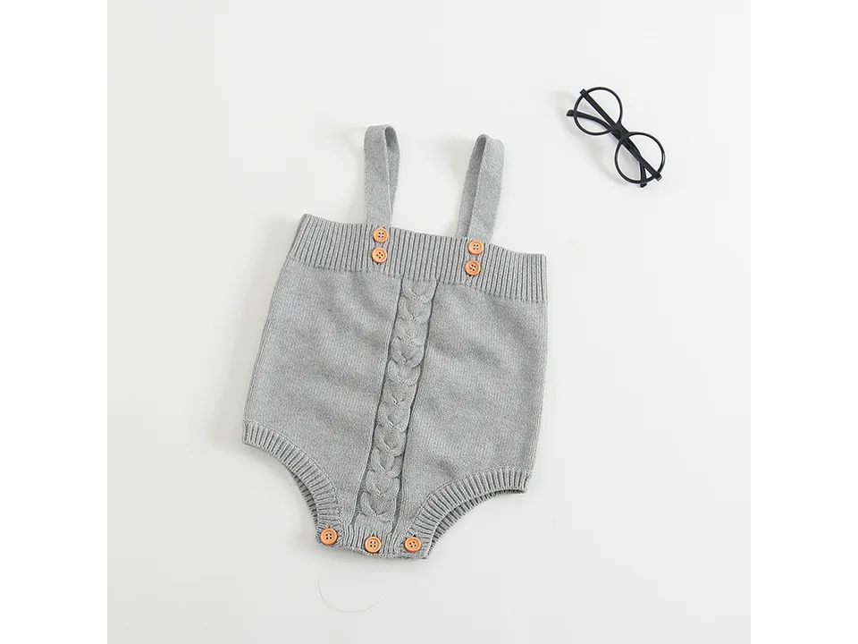 Front view of a grey knitted baby romper with button straps.