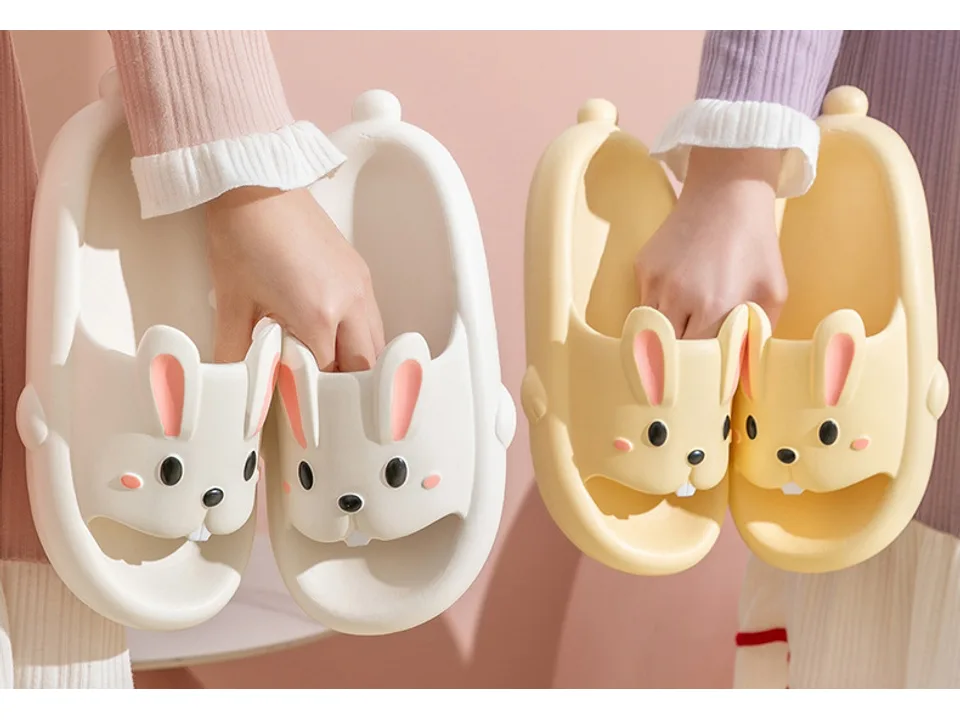 Two people holding up white and yellow rabbit-themed slides.