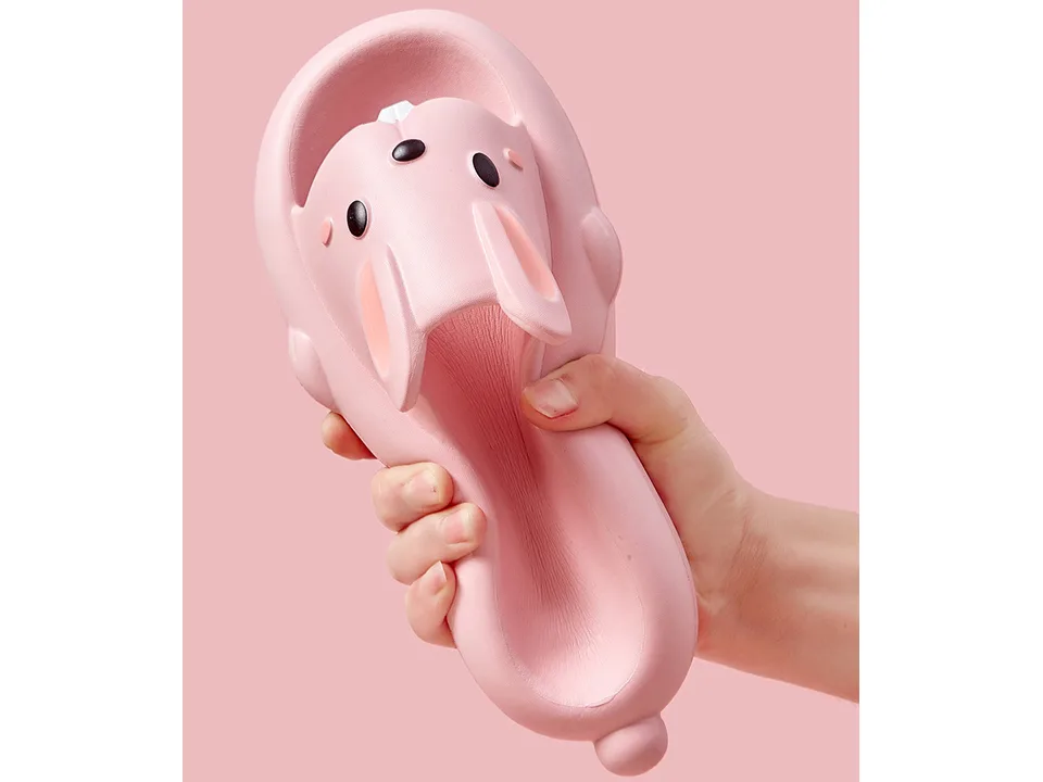 A hand squeezing a pink rabbit slide to show its flexible material.