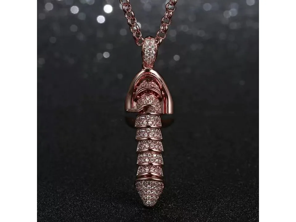 Rose gold pendant necklace with rhinestone detailing on a dark background.