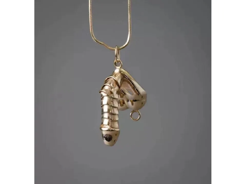 Gold-tone pendant necklace hanging against a grey background.