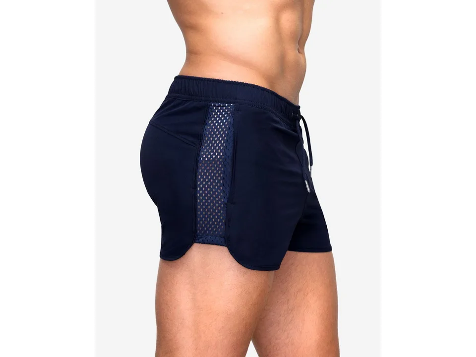 Side view of a man wearing navy blue athletic mesh shorts.