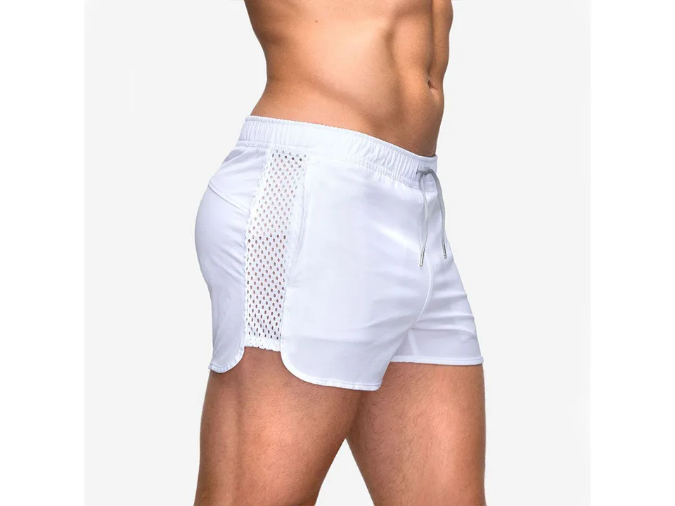 Side view of a man wearing white athletic mesh shorts.