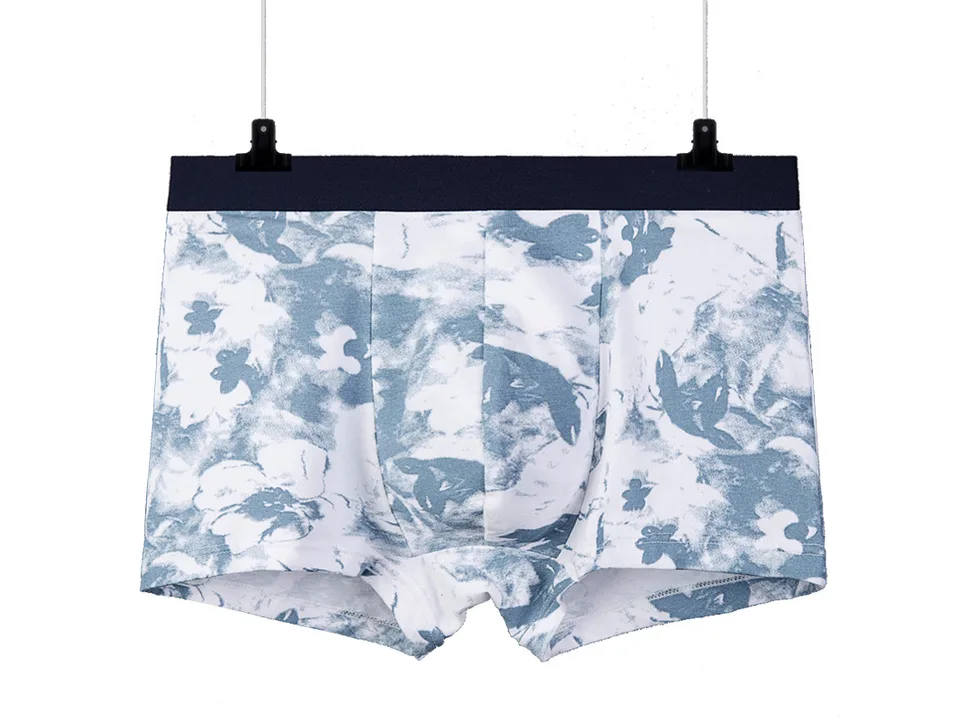 Blue and white floral pattern boxer briefs hanging on a hanger.