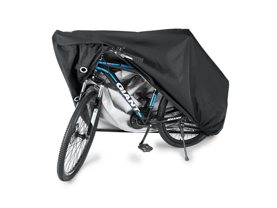 A bicycle partially covered by a black protective cover.