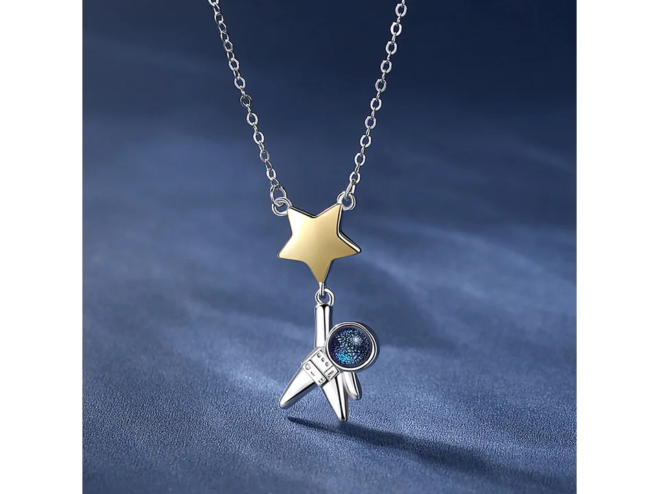 Close-up of the astronaut necklace with a star pendant on a blue background.