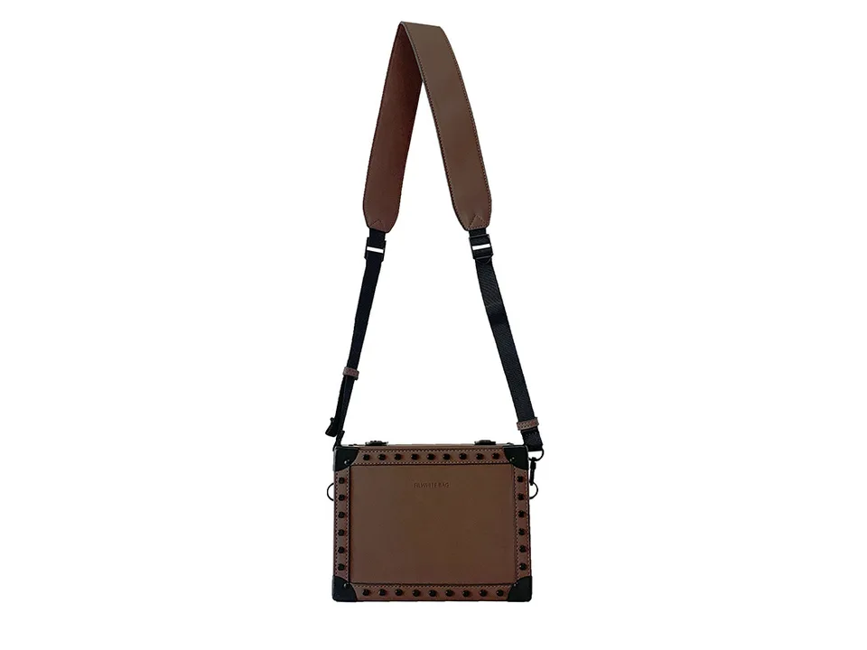 Brown square crossbody bag with studded details and adjustable shoulder strap.
