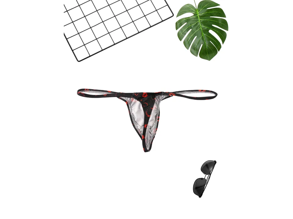 Black men's thong with red lip print, displayed with a grid and sunglasses.