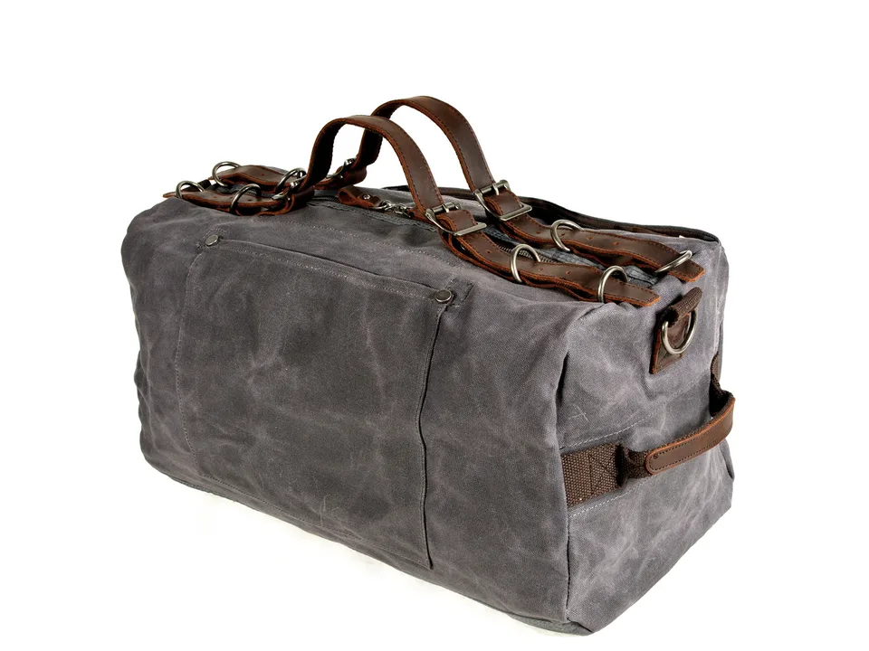 Grey canvas duffel bag with leather handles.