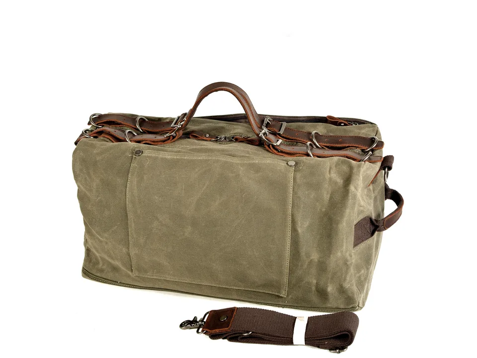 Green canvas duffel bag with leather handles and a detachable shoulder strap.